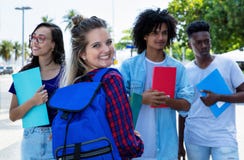 Lachende noordelijke Europese vrouwelijke student met groep vrienden stock afbeelding Lachende noordelijke Europese vrouwelijke student met groep vrienden stock afbeelding