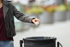 Lady hand throwing garbage to a trash bin Stock Photo Lady hand throwing garbage to a trash bin Stock Photo