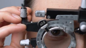 Lady putting on ophthalmic testing device for eye examination and lens selection stock video footage Lady putting on ophthalmic testing device for eye examination and lens selection stock video footage