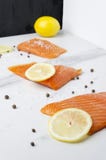 Laga mat av den rå smakliga laxen med den gula citronen och peppar i köket royaltyfri foto Laga mat av den rå smakliga laxen med den gula citronen och peppar i köket royaltyfri foto