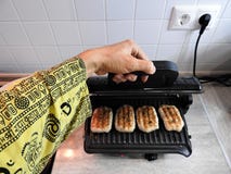 Laga mat på det elektriska gallret på tabellen hemma arkivbild Laga mat på det elektriska gallret på tabellen hemma arkivbild