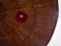 Lage hoekmening van een parasol met rode lamp in stro rieten patroon van lijnen en heldere hemel stock foto's Lage hoekmening van een parasol met rode lamp in stro rieten patroon van lijnen en heldere hemel stock foto's