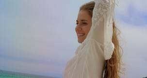 Lage hoekmening van Gelukkige Kaukasische vrouw status op het strand 4k stock videobeelden Lage hoekmening van Gelukkige Kaukasische vrouw status op het strand 4k stock videobeelden