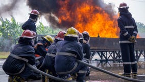 Laget av deltagare i utbildning för brandstridighet släcker enorm brand med vatten arkivfoto Laget av deltagare i utbildning för brandstridighet släcker enorm brand med vatten arkivfoto