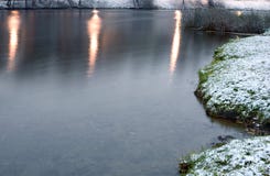 Lago no inverno com os raios claros refletidos nele imagem de stock royalty free Lago no inverno com os raios claros refletidos nele imagem de stock royalty free