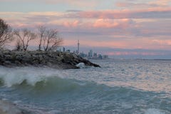 Lake Ontario at sunset with Toronto city skyline and CN Tower in the background.