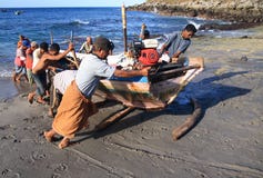 Lamalera Whalers, die ein Boot drücken lizenzfreie stockbilder Lamalera Whalers, die ein Boot drücken lizenzfreie stockbilder