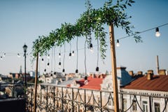 Lampade, caduta verde della ghirlanda sopra il balcone sulla cima del roo fotografie stock Lampade, caduta verde della ghirlanda sopra il balcone sulla cima del roo fotografie stock