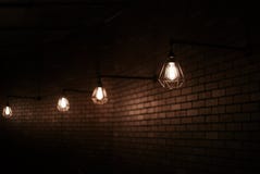 Lampade di Edison del metallo della vecchia scuola sul muro di mattoni marrone fotografia stock libera da diritti Lampade di Edison del metallo della vecchia scuola sul muro di mattoni marrone fotografia stock libera da diritti