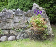 Landschaft mit Pansies in einem großen Topf und in einem dekorativen Fahrrad stockfoto Landschaft mit Pansies in einem großen Topf und in einem dekorativen Fahrrad stockfoto