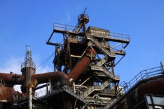 Landschaftspark Duisburg, Germany: Low angle view on stairways into deep blue sky at corroded tower with rusty pipeline stock images Landschaftspark Duisburg, Germany: Low angle view on stairways into deep blue sky at corroded tower with rusty pipeline stock images