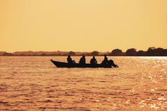Landschap bij zonsondergang van een boot met vissers die op Pantanal vissen royalty-vrije stock afbeeldingen Landschap bij zonsondergang van een boot met vissers die op Pantanal vissen royalty-vrije stock afbeeldingen