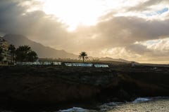 Landschap van de rotsachtige kust van de Atlantische Oceaan met enige palm en bewolkte hemel Zacht geel ochtendlicht Royalty-vrije Stock Foto's Landschap van de rotsachtige kust van de Atlantische Oceaan met enige palm en bewolkte hemel Zacht geel ochtendlicht Royalty-vrije Stock Foto's