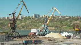 Landschap van sleepboten en kranen in scheepswerf in ladingshaven De kraan beweegt zand door vrachtwagens in een ladingsterminal Landschap van sleepboten en kranen in scheepswerf in ladingshaven De kraan beweegt zand door vrachtwagens in een ladingsterminal
