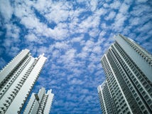 Lange gebouwen tegen een bewolkte blauwe hemel stock foto Lange gebouwen tegen een bewolkte blauwe hemel stock foto