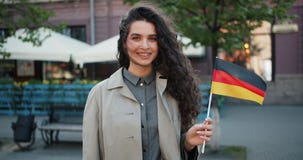 Langzaam motieportret dat van Duitse patriot zich in openlucht met vlag van Duitsland bevindt stock footage Langzaam motieportret dat van Duitse patriot zich in openlucht met vlag van Duitsland bevindt stock footage
