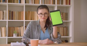 Lanzamiento del primer de la empresaria caucásica joven que usa la tableta y mostrando la pantalla verde a la cámara en la oficin metrajes Lanzamiento del primer de la empresaria caucásica joven que usa la tableta y mostrando la pantalla verde a la cámara en la oficin metrajes