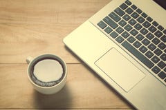 Lap-top με το φλυτζάνι καφέ στον παλαιό ξύλινο πίνακα Στοκ Φωτογραφία Lap-top με το φλυτζάνι καφέ στον παλαιό ξύλινο πίνακα Στοκ Φωτογραφία