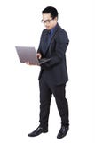 Lap-top στάσης και χρήσης επιχειρηματιών στο στούντιο στοκ εικόνες Lap-top στάσης και χρήσης επιχειρηματιών στο στούντιο στοκ εικόνες