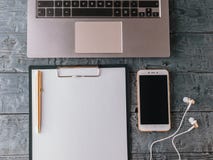 Laptop, tablet with paper, smartphone, pen and earphones on wooden table. The view from the top. Stock Images Laptop, tablet with paper, smartphone, pen and earphones on wooden table. The view from the top. Stock Images