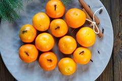 Laranja brilhante das tangerinas madura com folhas verdes em uma placa cinzenta com ramos do abeto na tabela de madeira Ajuste da imagem de stock royalty free Laranja brilhante das tangerinas madura com folhas verdes em uma placa cinzenta com ramos do abeto na tabela de madeira Ajuste da imagem de stock royalty free