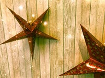 Large cute red holiday stars, Christmas, New Year`s decoration against the background of glowing gerlyand wooden vertical boards royalty free stock photo Large cute red holiday stars, Christmas, New Year`s decoration against the background of glowing gerlyand wooden vertical boards royalty free stock photo