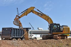 A large excavator dumps dirt into a truck royalty free stock photography A large excavator dumps dirt into a truck royalty free stock photography