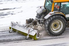 Large snow plowing tractor machine at work on the road during a snow storm in winter. stock image Large snow plowing tractor machine at work on the road during a snow storm in winter. stock image
