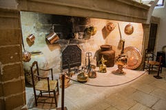 Large stone fireplace with decorative copper kitchenware and chairs in Lourmarin castle. royalty free stock photo Large stone fireplace with decorative copper kitchenware and chairs in Lourmarin castle. royalty free stock photo