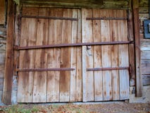 Large wooden doors of the old barn with iron canopies royalty free stock photo Large wooden doors of the old barn with iron canopies royalty free stock photo