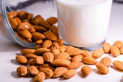 Las almendras marrones enteras se cierran encima de macro y de la leche de la almendra fotografía de archivo Las almendras marrones enteras se cierran encima de macro y de la leche de la almendra fotografía de archivo