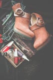Las botas marrones del tobillo del ante mienten en un fondo oscuro Al lado de la caja con los accesorios de las mujeres Foco sele imagen de archivo libre de regalías Las botas marrones del tobillo del ante mienten en un fondo oscuro Al lado de la caja con los accesorios de las mujeres Foco sele imagen de archivo libre de regalías