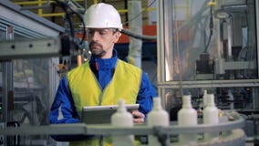 Las botellas plásticas abiertas están pasando por el empleado de sexo masculino de la fábrica almacen de video Las botellas plásticas abiertas están pasando por el empleado de sexo masculino de la fábrica almacen de video