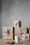 Las cajas de regalo de la Navidad adornadas con el cordón y las estrellas al lado de un vidrio de leche y de las galletas, forma fotos de archivo libres de regalías Las cajas de regalo de la Navidad adornadas con el cordón y las estrellas al lado de un vidrio de leche y de las galletas, forma fotos de archivo libres de regalías