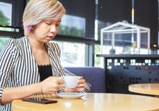 Las empresarias sostienen la taza de café en la cafetería imagenes de archivo Las empresarias sostienen la taza de café en la cafetería imagenes de archivo