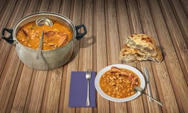 Las habas cocieron con las costillas de cerdo ahumadas servidas con Flatbread leudado nacional en la estera de lugar de madera de Imagenes de archivo Las habas cocieron con las costillas de cerdo ahumadas servidas con Flatbread leudado nacional en la estera de lugar de madera de Imagenes de archivo
