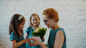 Las hijas preciosas dan a mamá un regalo y las flores Las hijas preciosas dan a mamá un regalo y las flores