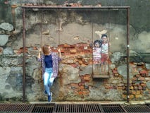 Las ilustraciones de la pared llamaron ‘Brother y a la hermana en un oscilación ‘ fotografía de archivo libre de regalías Las ilustraciones de la pared llamaron ‘Brother y a la hermana en un oscilación ‘ fotografía de archivo libre de regalías