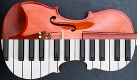 las llaves del piano adentro al violín en la tabla de cuero negra, medio teclado les gusta forma del violín foto de archivo las llaves del piano adentro al violín en la tabla de cuero negra, medio teclado les gusta forma del violín foto de archivo