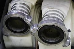 Las mangueras de bomberos están en el compartimiento del coche de bomberos, cabezas de la conexión de la manguera de bomberos cer foto de archivo libre de regalías Las mangueras de bomberos están en el compartimiento del coche de bomberos, cabezas de la conexión de la manguera de bomberos cer foto de archivo libre de regalías