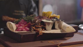 Las manos del cocinero en guantes negros del cocinero que adornaba con la rama de la hierba asaron a la parrilla la carne que men metrajes Las manos del cocinero en guantes negros del cocinero que adornaba con la rama de la hierba asaron a la parrilla la carne que men metrajes