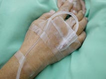 Las manos del paciente mayor con IV la línea intravenosa fotografía de archivo libre de regalías Las manos del paciente mayor con IV la línea intravenosa fotografía de archivo libre de regalías