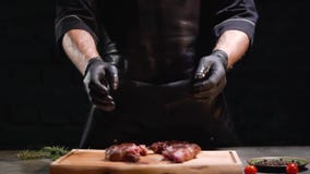 Las manos en guantes de goma negros lanzan dos pedazos de carne en el cierre de la tabla de cortar para arriba Cámara lenta Cierr almacen de metraje de vídeo Las manos en guantes de goma negros lanzan dos pedazos de carne en el cierre de la tabla de cortar para arriba Cámara lenta Cierr almacen de metraje de vídeo