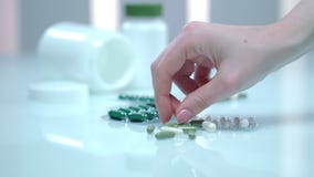Las manos femeninas toman la píldora verde de la tabla Cápsula de la medicina alternativa almacen de metraje de vídeo Las manos femeninas toman la píldora verde de la tabla Cápsula de la medicina alternativa almacen de metraje de vídeo