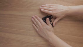 Las manos humanas llenan para arriba las alubias negras en la tabla de madera metrajes Las manos humanas llenan para arriba las alubias negras en la tabla de madera metrajes