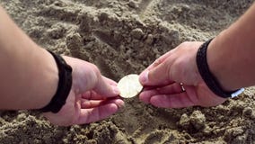Las manos masculinas cavan en arena y encuentran el bitcoin del oro almacen de video Las manos masculinas cavan en arena y encuentran el bitcoin del oro almacen de video