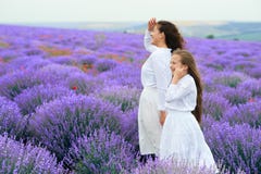 Las muchachas est?n en el campo de flor de la lavanda, paisaje hermoso del verano imagen de archivo libre de regalías Las muchachas est?n en el campo de flor de la lavanda, paisaje hermoso del verano imagen de archivo libre de regalías