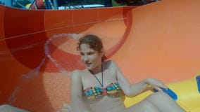 Las muchachas felices que van abajo de un waterslide en el agua parquean metrajes Las muchachas felices que van abajo de un waterslide en el agua parquean metrajes