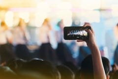 Las muchachas utilizan smartphones para tomar imágenes en los conciertos imágenes de archivo libres de regalías Las muchachas utilizan smartphones para tomar imágenes en los conciertos imágenes de archivo libres de regalías