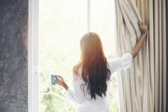 Las mujeres asiáticas que beben el café y despiertan en su cama descansada completamente imagen de archivo libre de regalías Las mujeres asiáticas que beben el café y despiertan en su cama descansada completamente imagen de archivo libre de regalías